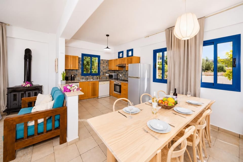 Open-plan living room with sofa, dining area, kitchen, A/C, WiFi internet, and satellite TV