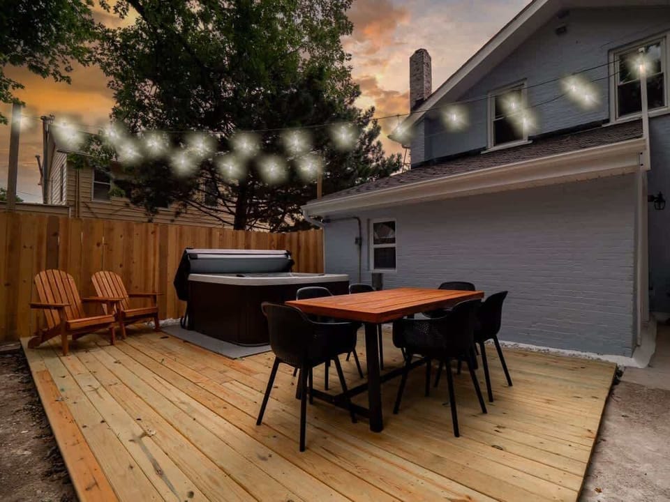 - Outdoor deck with dining table seating under glowing string lights   - Relax in the hot tub or lounge on Adirondack chairs for evening vibes   - Perfect space for gatherings and memorable Airbnb stays  
