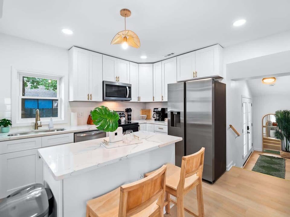 - Sleek kitchen with stainless steel appliances and marble counters   - Spacious island with seating ideal for cooking and gathering   - Fully equipped Airbnb kitchen ready for extended guest stays  
