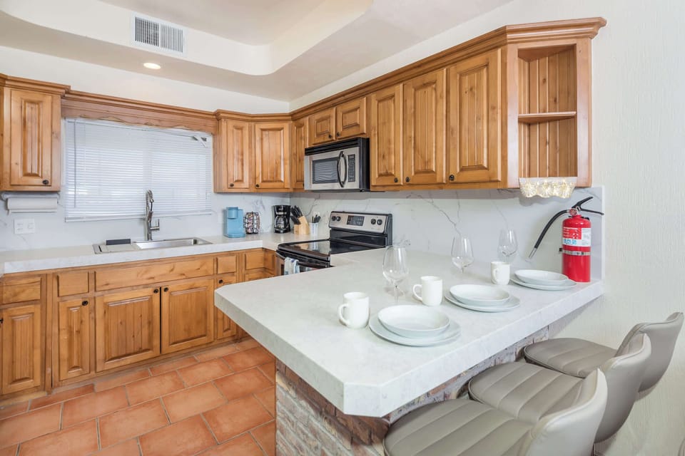 Spacious kitchen with natural wood cabinetry, modern appliances, and a breakfast bar for casual dining or morning coffee.
