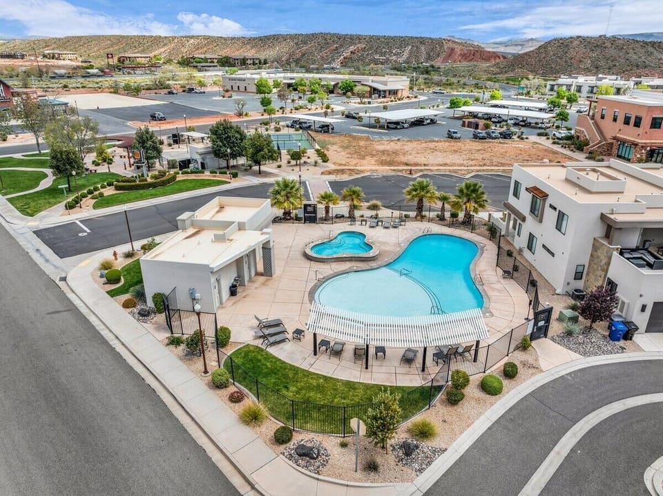 Resort-style community pool in Washington Utah vacation rental neighborhood with hot tub, lounge chairs, and mountain backdrop near St. George.
