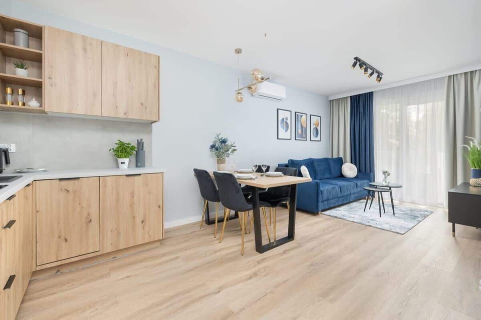 A bright living area with a dining space and kitchenette invites guests to enjoy quality time in an open, homey environment.