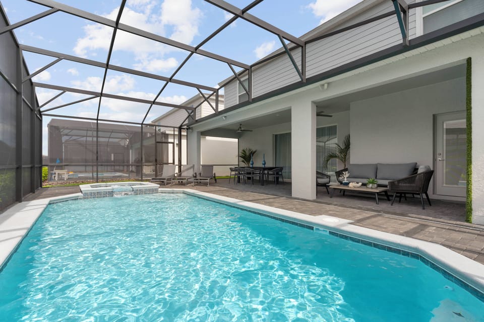 Enjoy ultimate relaxation in your private pool, surrounded by a stylish screen enclosure that lets in natural light. The elegant stone patio with cozy lounge furniture is perfect for sun-soaking and unwinding.