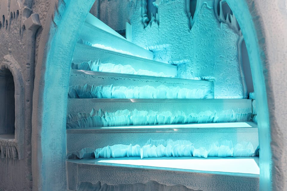 Ascend the illuminated ice-blue staircase surrounded by textured icy walls, creating a captivating atmosphere. The ethereal glow and intricate frost details ensure a truly memorable experience for all guests.