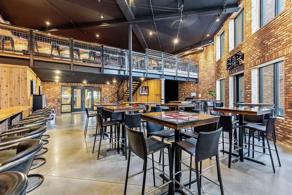 Lively dining & lounge area w/ bar seating, string lights & open-air feel