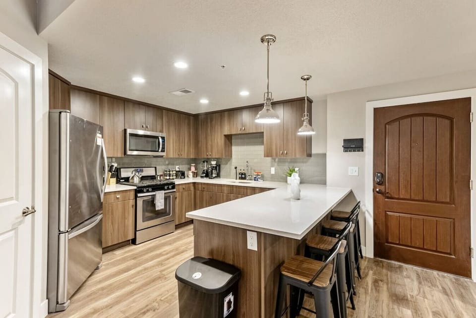 Sleek kitchen w/ large island, bar stools & stainless appliances for easy meals