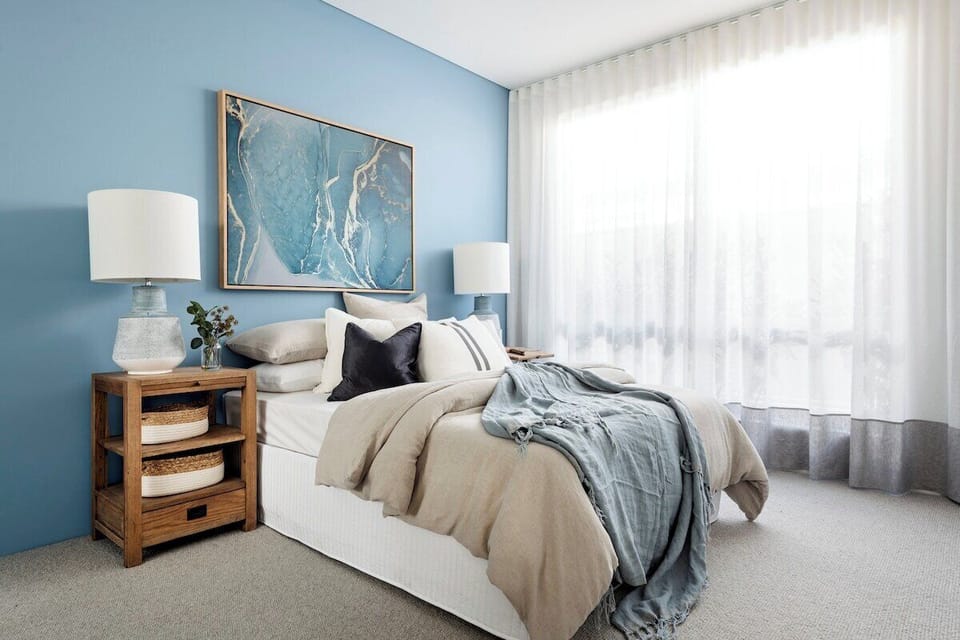Settle into the plush queen bed, surrounded by calming blue hues, elegant coastal artwork and soft natural light for a restful night's sleep.