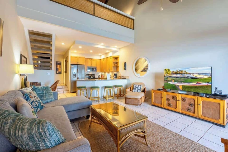Living room features sectional couch, ceiling fan, smart TV with cable, sitting chairs and plenty of natural light.