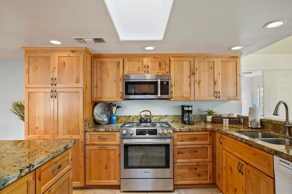 Fully equipped Chef's kitchen featuring a gas range, air fryer, blender, waffle maker, juicer, hot water kettle, coffee maker, and electric griddle — plus all cooking and dining essentials for the perfect stay at The Birdhouse SD.
