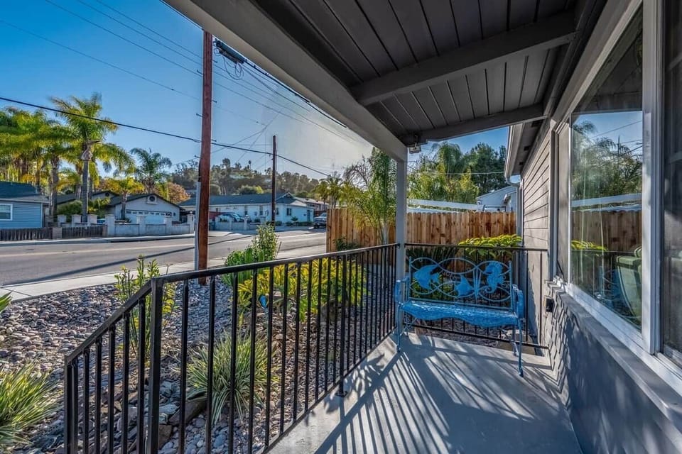 Cozy front porch with a fun bench — a great place to sip your morning coffee, relax in the sunshine, and enjoy the calm surroundings at The Birdhouse SD.