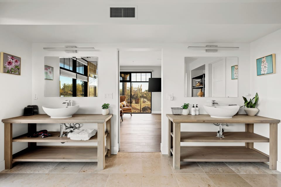 Jr. primary ensuite bathroom with walk-in shower, double vanities, and toilet