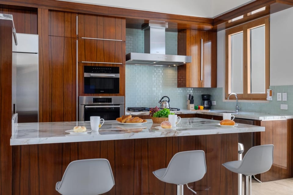 Step into this modern kitchen, where sleek stainless steel appliances and generous countertops come together to create a culinary haven, ideal for cooking enthusiasts and entertainers alike, offering a seamless blend of form and function