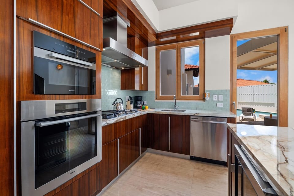 This impressive kitchen showcases a stunning collection of stainless steel appliances, beautifully complemented by ample countertops,