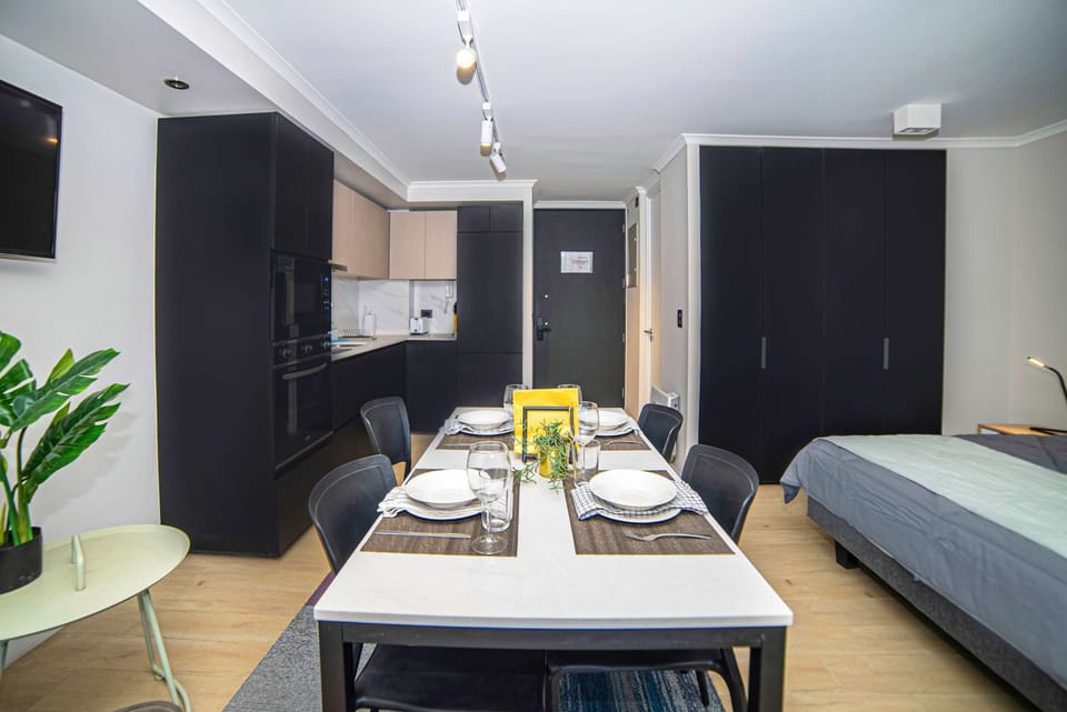 Chic studio with modern kitchen and dining area, perfect for a cozy stay in the heart of the city.