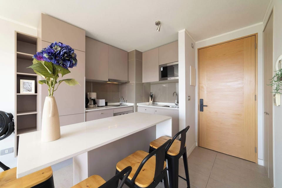 Modern kitchen with sleek design and cozy breakfast bar, perfect for enjoying a morning coffee.