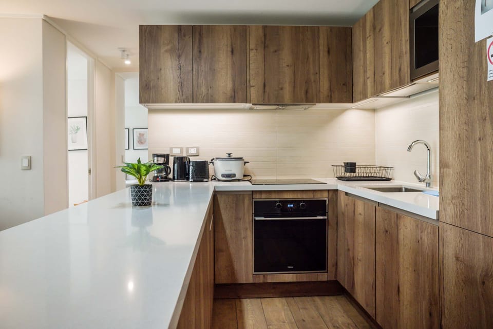 Modern kitchen with sleek wooden cabinetry and all essentials for a delightful cooking experience.