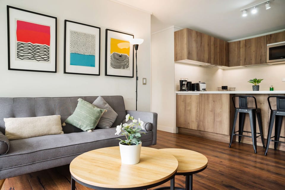 Stylish living area with vibrant art and a modern kitchen, perfect for relaxation and entertaining.
