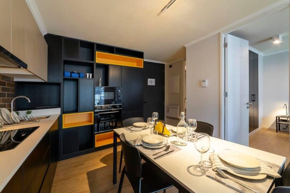 Enjoy a cozy meal in this stylish dining area with modern kitchen amenities, perfect for a relaxing stay.