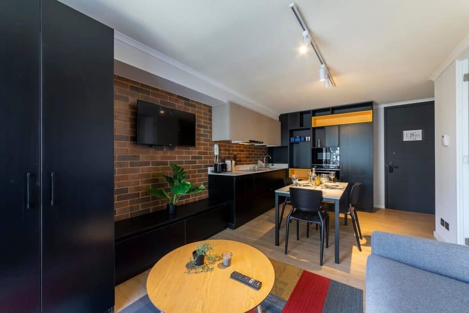 Modern studio with sleek kitchen and cozy dining area, perfect for a comfortable stay in the heart of the city.