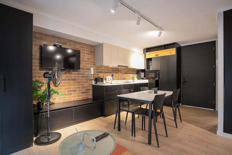 Modern kitchen with stylish brick accents and dining area, perfect for cozy meals in a chic setting.