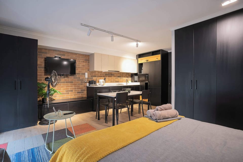 Cozy studio with modern kitchenette and stylish decor, perfect for a relaxing stay in the heart of the city.