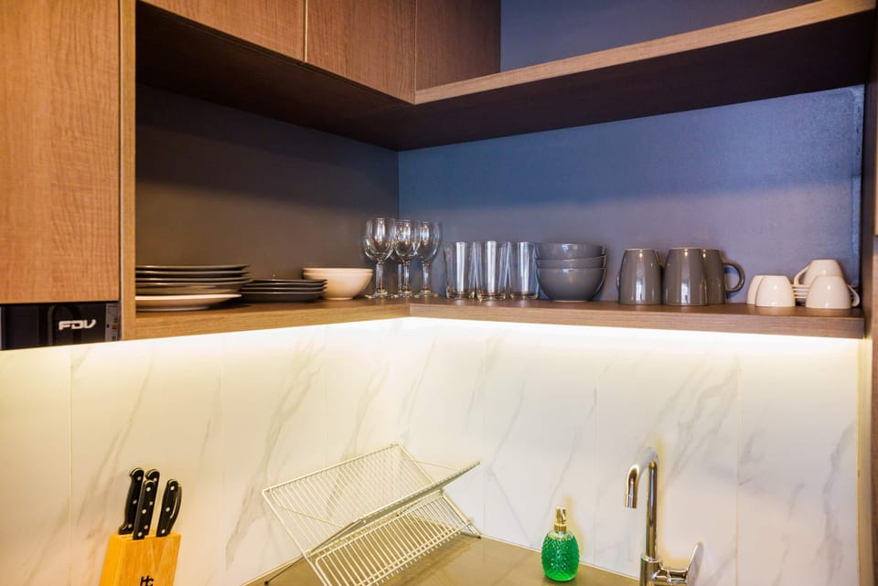 Modern kitchen with elegant dishware and warm lighting, perfect for cozy meals.