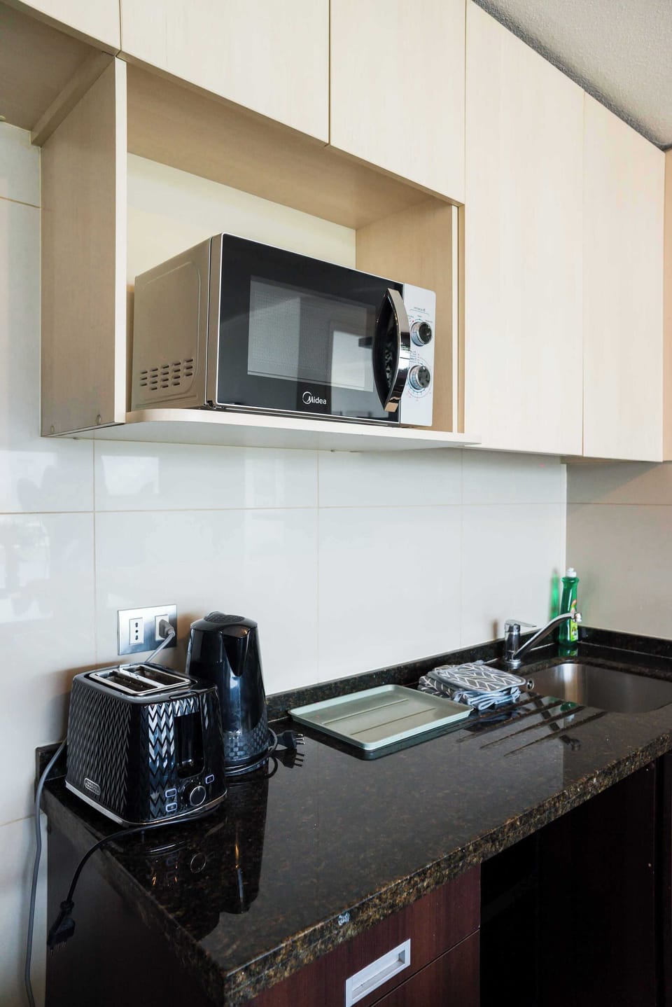 Modern kitchen with sleek appliances and granite countertops, perfect for preparing meals in style.