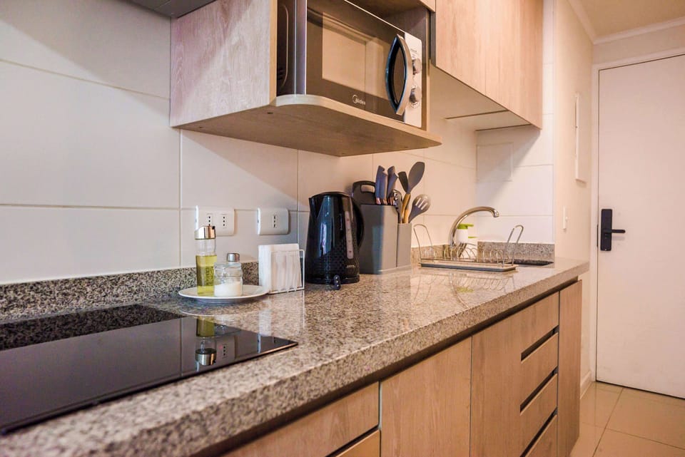 Modern kitchen with sleek granite countertops and essential appliances, perfect for preparing meals in comfort.