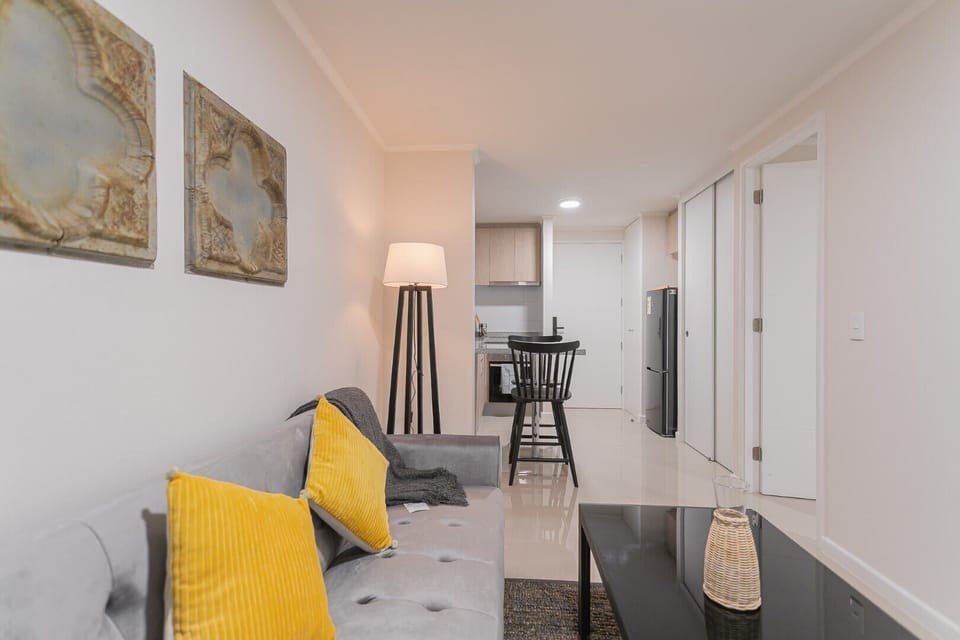 Cozy living space with a comfortable sofa and modern kitchen, perfect for relaxation and dining.
