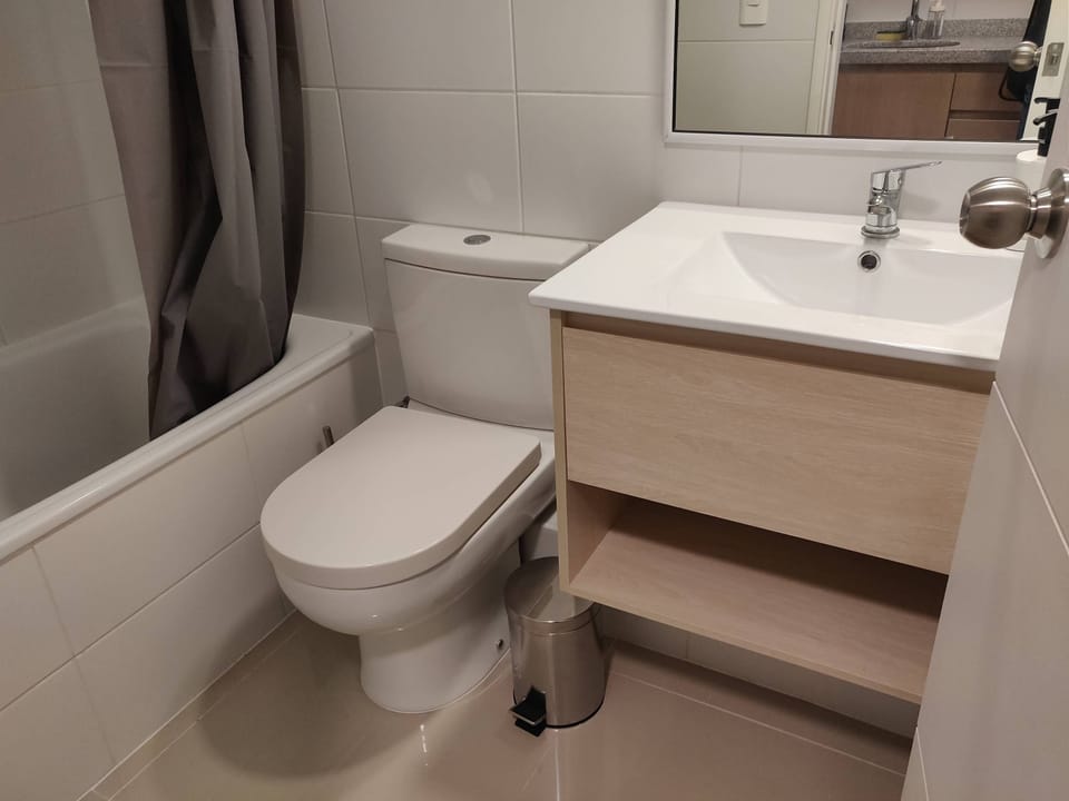 Modern bathroom with sleek fixtures and a cozy bathtub, perfect for relaxation after a day exploring the city.