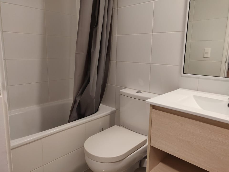 Modern bathroom with sleek fixtures and a relaxing bathtub, perfect for unwinding after a day of exploring.