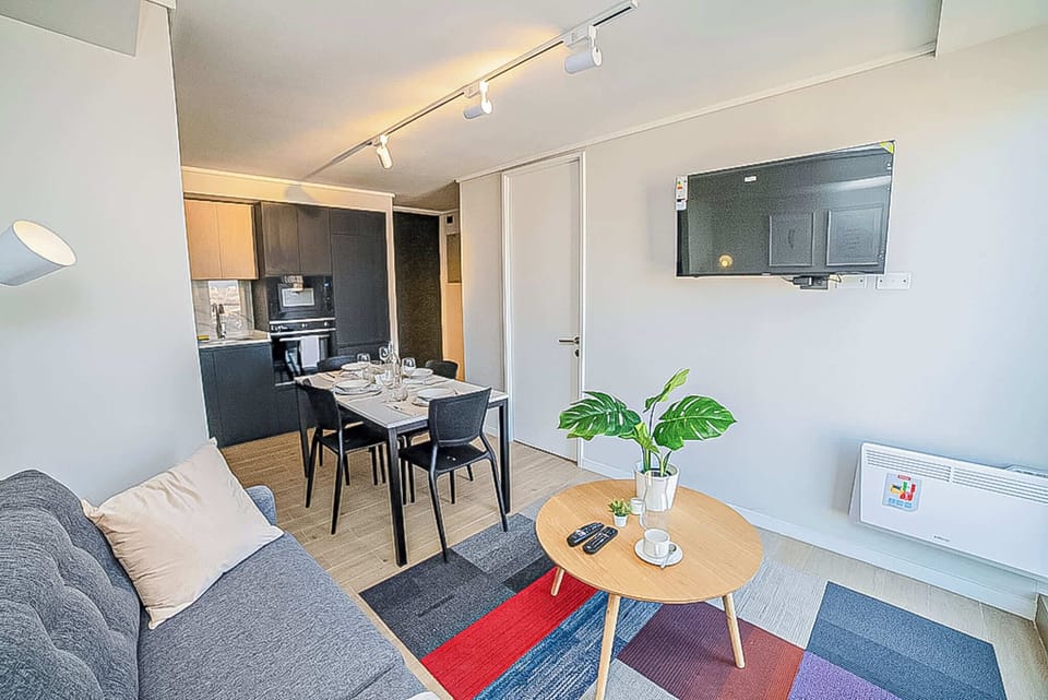 Cozy and modern living space with a vibrant rug and dining area, perfect for a relaxing stay.