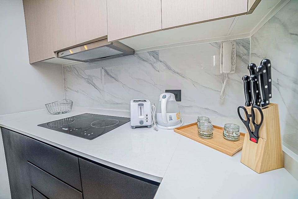 Sleek and modern kitchen equipped with essentials for a comfortable stay, including a cooktop, toaster, and kettle.