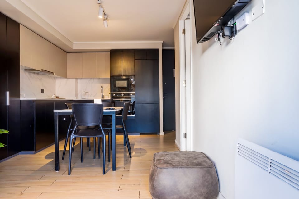 Modern kitchen and dining area with sleek design, perfect for cozy meals in a stylish studio.