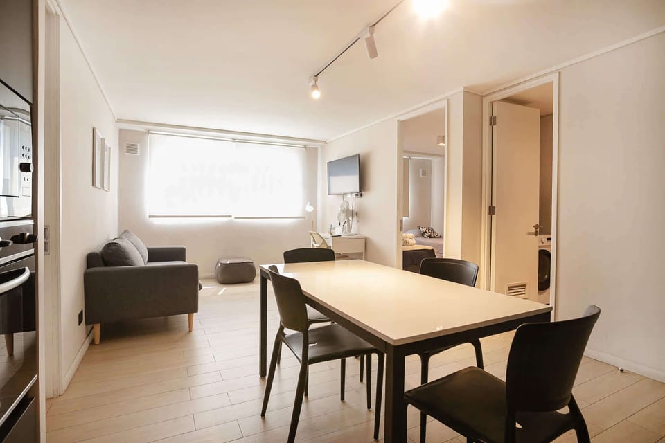 Bright and modern living space with a cozy sofa and dining area, perfect for relaxing after a day of exploring.
