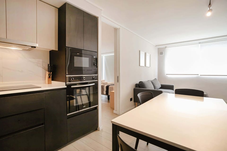 Sleek and modern kitchen with open living space, perfect for a cozy stay in the heart of the city.