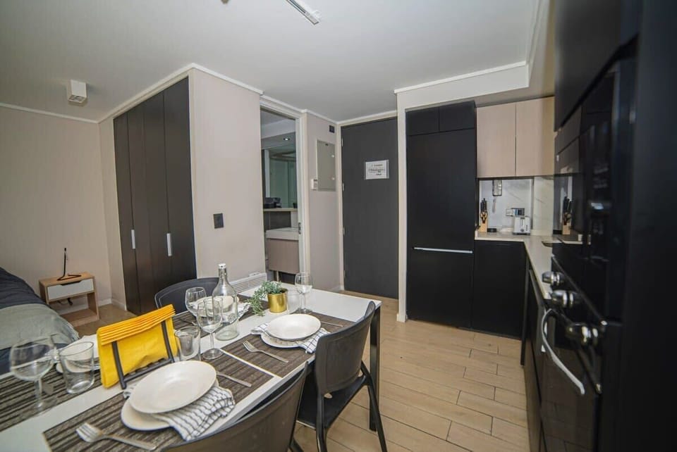 Cozy studio kitchen with modern amenities and a stylish dining area, perfect for a comfortable stay.