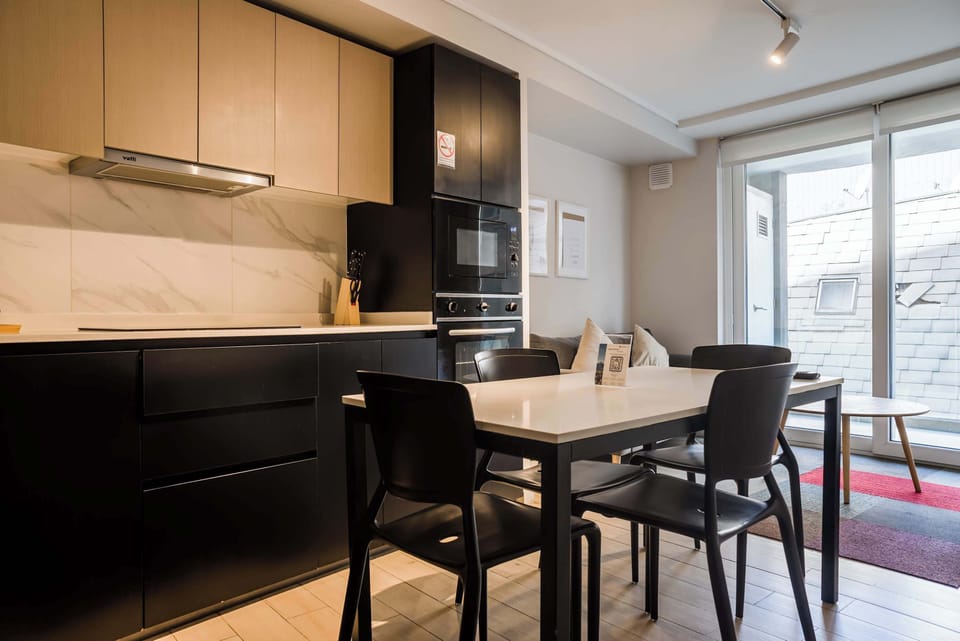 Modern kitchen and dining area with sleek finishes and ample natural light, ideal for cozy meals.