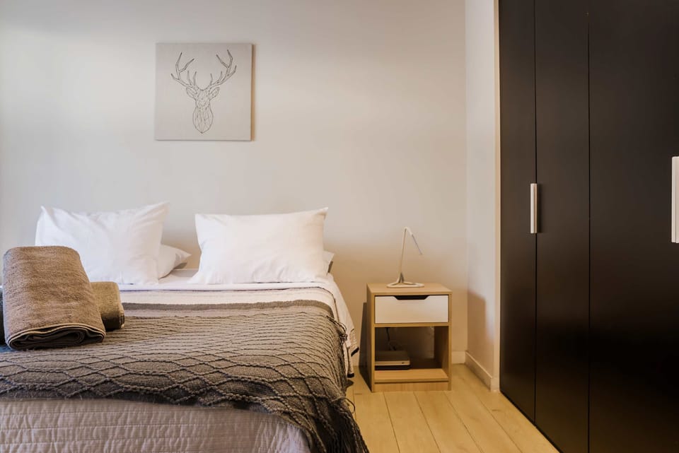 Relax in this stylish bedroom featuring a comfortable bed, modern decor, and ample storage space.