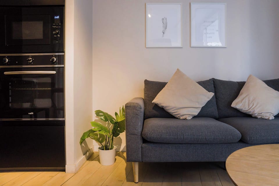 Unwind in this cozy living area with a comfy sofa and modern appliances, perfect for relaxing after exploring the city.