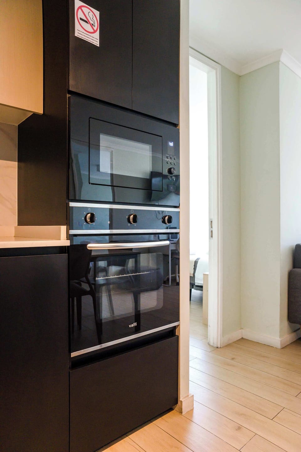 Modern kitchen with sleek appliances and a cozy glimpse into the bedroom, perfect for a comfortable stay.