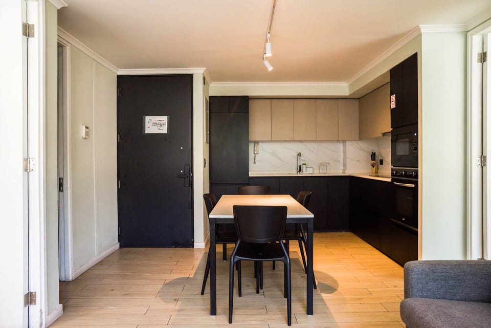 Modern kitchen with sleek cabinetry and a cozy dining area, perfect for intimate meals.