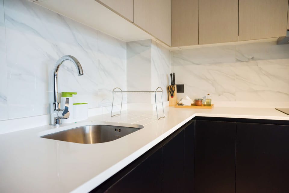 Modern kitchen with marble backsplash and stainless steel fixtures, ideal for culinary adventures.