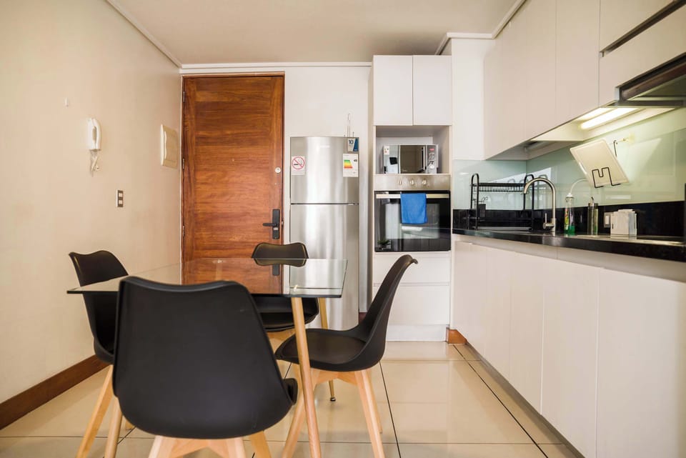 Private kitchen with stainless-steel appliances, a glass dining table, and seating for shared meals.