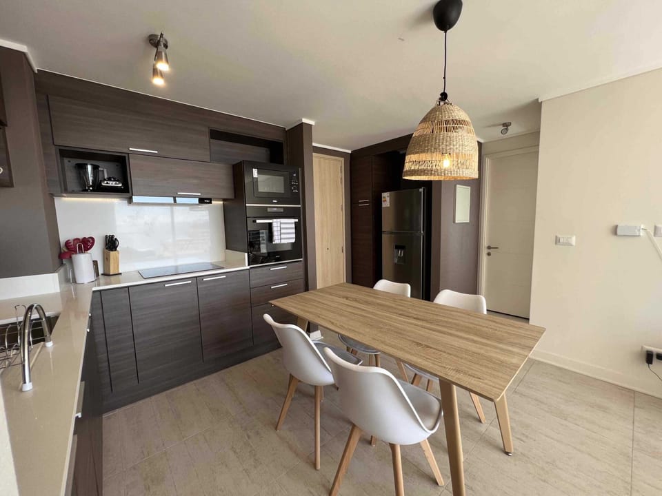 Sleek and modern kitchen with integrated dining area, perfect for cozy meals and gatherings.