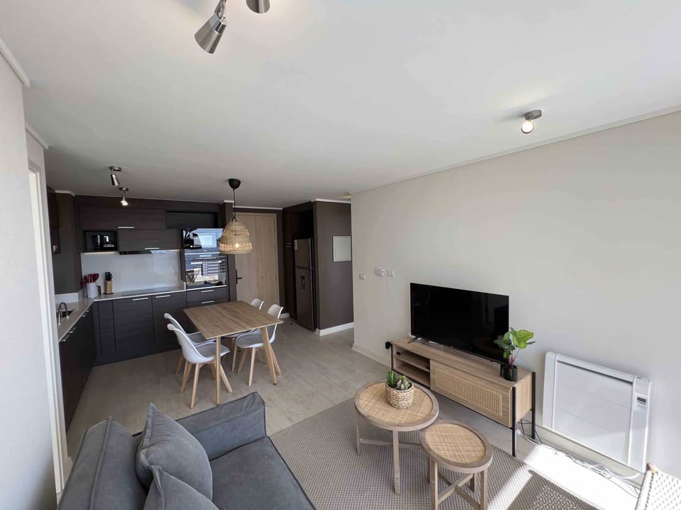 Modern living-dining area with integrated kitchen, perfect for relaxing and entertaining in style.