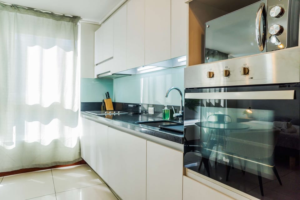 Sleek and modern kitchen with ample natural light, perfect for cooking and dining in style.
