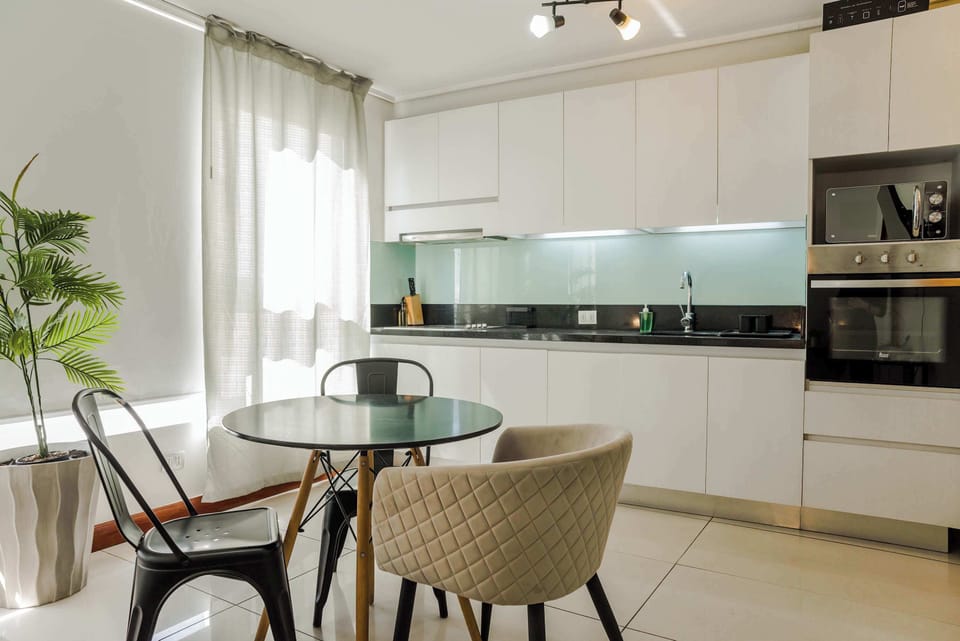 Bright and modern kitchen with sleek appliances and a cozy dining area, perfect for enjoying meals in style.