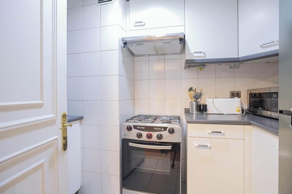 Cozy kitchen equipped with modern appliances, perfect for preparing meals in the comfort of your studio apartment.