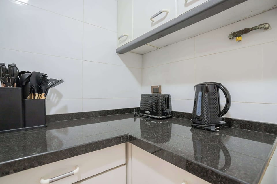 Sleek kitchen corner with modern appliances and ample counter space, ideal for meal prep.